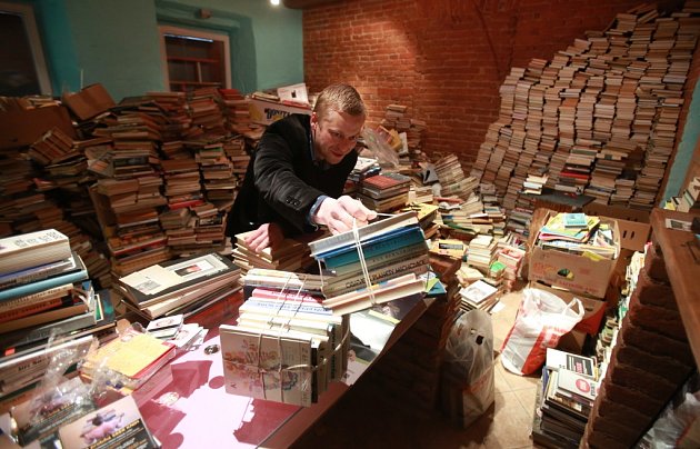 Jakub Albín, jeden ze spolupořadatelů festivalu Literatura žije, ukazuje v Literární kavárně Měsíc ve dne, kolik knih jim přinesli lidé díky sbírce do pouliční veřejné knihovny v Českých Budějovicích.