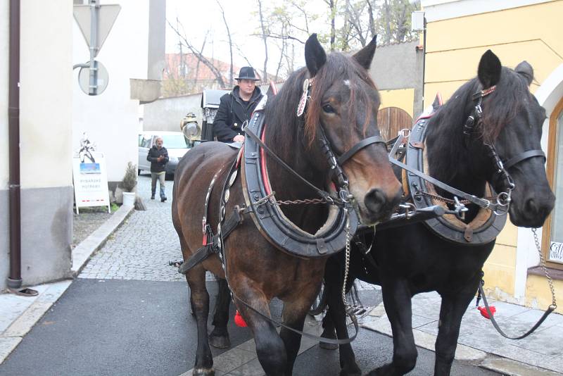 Pohřební kočár s dvěma koňmi projíždí centrem města.