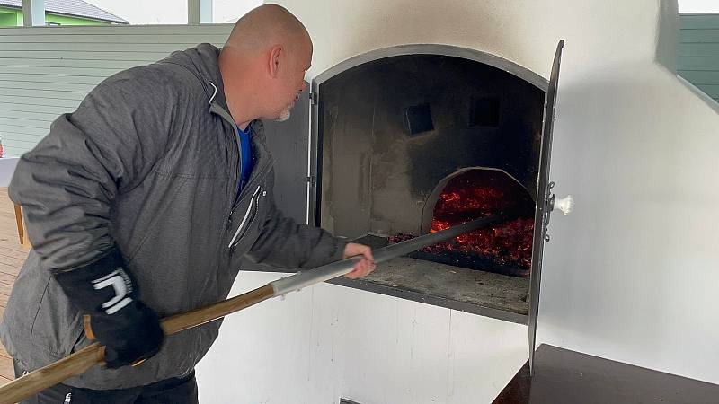 V Úsilném na Českobudějovicku v sobotu poprvé pekli chleba, housky a česnekové placky v nově postavené obecní peci. S přípravou těsta a radami pro správné sázení pečiva do pece pomáhal místním pan Augustin Sobotovič z Volar, který má zkušenosti s pečením 