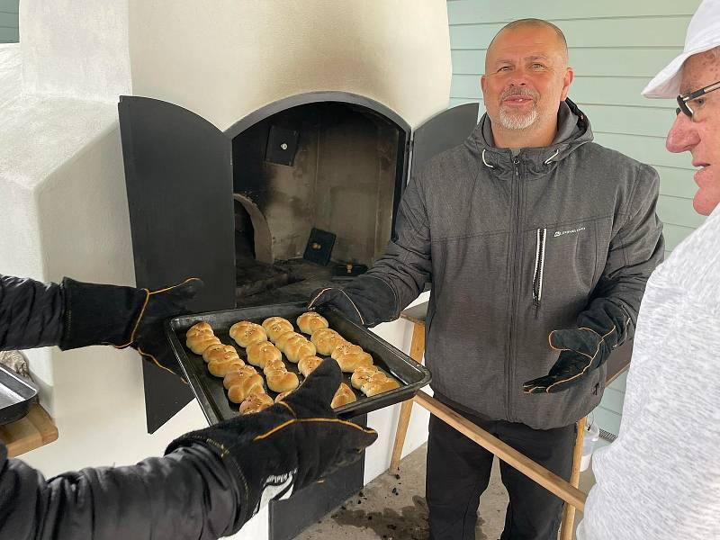 V Úsilném na Českobudějovicku v sobotu poprvé pekli chleba, housky a česnekové placky v nově postavené obecní peci. S přípravou těsta a radami pro správné sázení pečiva do pece pomáhal místním pan Augustin Sobotovič z Volar, který má zkušenosti s pečením 