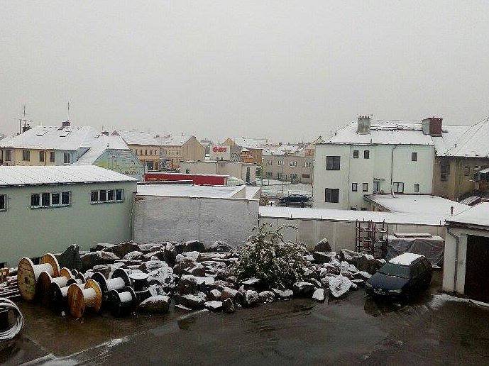 České Budějovice - Tovární a Rudolfovská ulice. Jen zasněžené střechy, na silnicícz mokro.