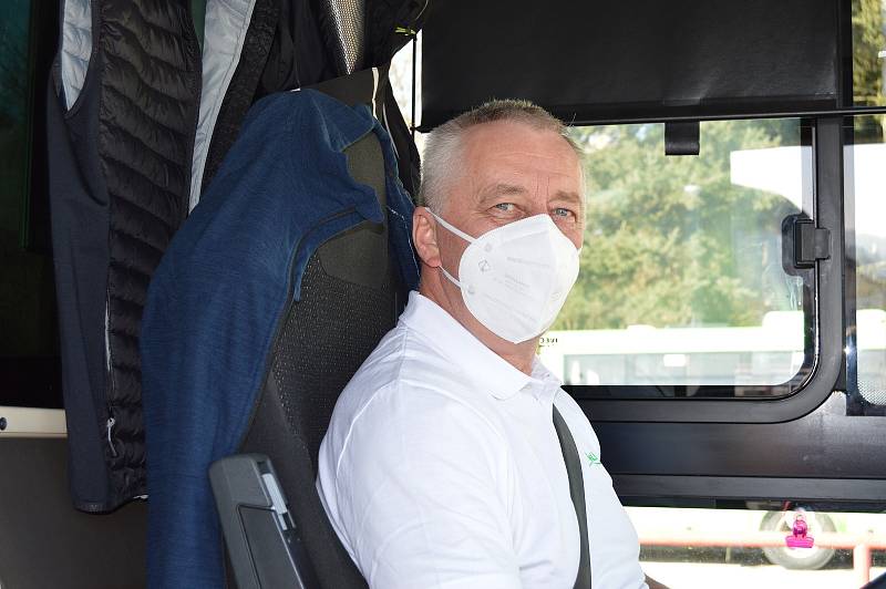 Ilustrační foto řidiče s respirátorem a seřazených autobusů společnosti BusLine.