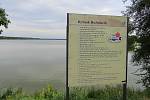 Rybník Rožmberk v roce 2022, povodně zde připomíná cedulka s udáním výšky velké vody na stavidle a celá informační tabule s historickými snímky od Rybářství Třeboň.