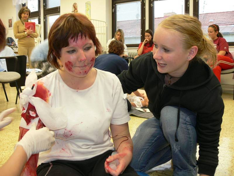 Studentky Zdravotnické školy v Českých Budějovicíh ošetřují figurantku Petru Dvořákovou z 2.A, která představuje zraněného s tepenným krvácením.