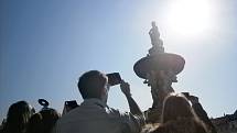 Lidé pozorují zatmění Slunce na českobudějovickém náměstí.