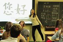 Stážistka Muying Li z Číny učí sedmáky pozdrav v čínštině. Žáci si zkoušeli napsat své jméno čínskými znaky, které se děti v Číně učí od 6 do 18 let, každý den 15 znaků.