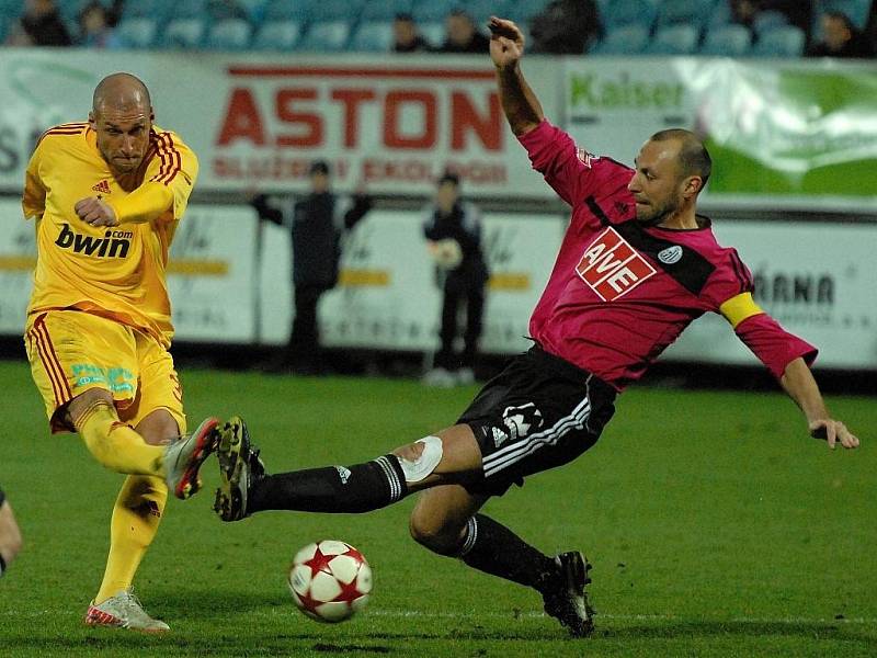 Fotbalisté Dynama sice za přípravou budou jezdit v zimě vesměs mimo kraj (na snímku z duelu s Duklou Roman Lengyel blokuje střelu Lietavy), i tak ale bude fotbalová zima na jihu Čech pestrá.