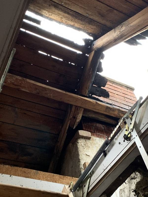 Požár zničil v neděli 9. ledna 2022 střechu rodinného domu v českobudějovické Čéčově ulici a poničil i sousední střechy. Například v domě s regionálním sídlem KSČM. Foto: Květa Šlahúnková