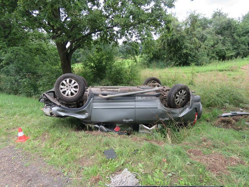 Auto skončilo mimo silnici na střeše.