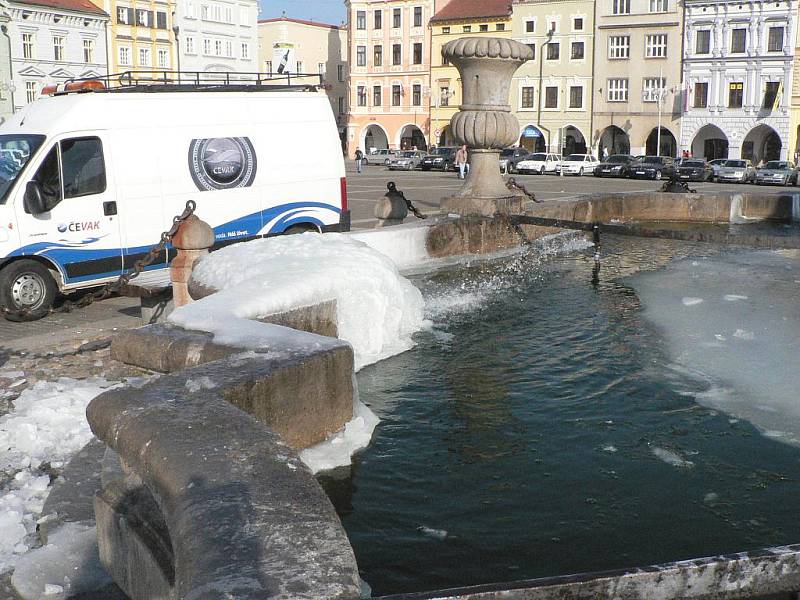 Čištění Samsonovy kašny v Českých Budějovicích od ledu.