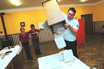 Člen volební komise v Dlouhé Lhotě na Táborsku  Radek Čihák vysypává hlasovací lístky z volební urny.