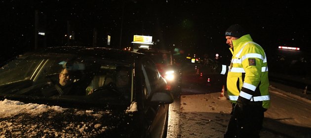 Policisté, kteří kontrolují auta na hraničním přechodu Dolní Dvořiště, zažívají nyní mrazivé noci, kdy teplota padá k minus deseti a ještě níž. Nejhorší pro ně je ledový vítr. Na snímku z neděle 17. ledna  policista Václav Novák.