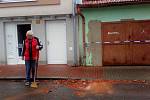 Muž před domem uklízel rozbité tašky ze střechy v Českých Budějovicích v Baarově ulici.