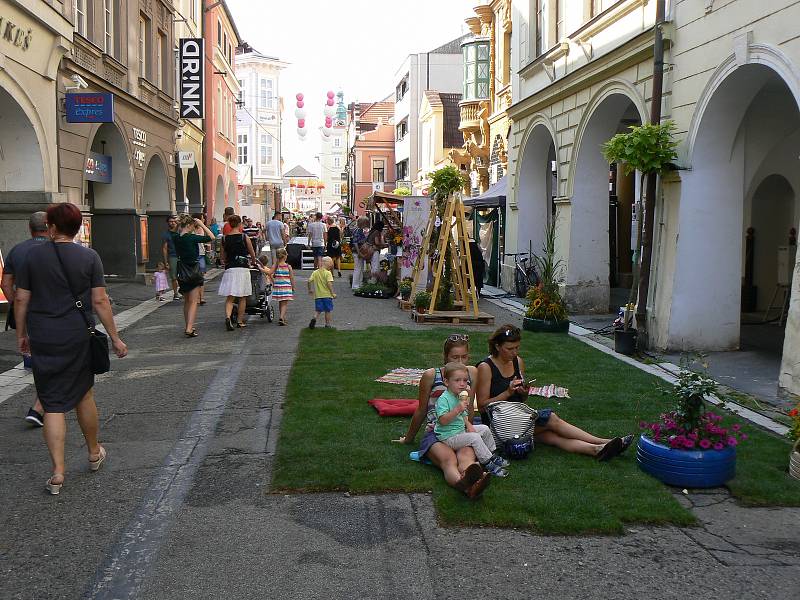 V centru Budějovic v sobotu vrcholí dvoudenní festival Město lidem, lidé městu. Z ulic zmizela auta, dlažbu přikryl umělý trávník a zastínily deštníky zavěšené ve výšce. Mezi domy se konají koncerty, módní přehlídky a další akce.