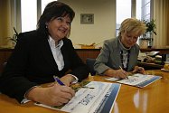 Michaela Čermáková (vlevo) a Ivana Stráská podepisují darovací šek. 