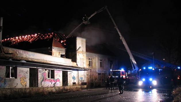 Vysoko šlehající plameny ze střechy bývalé sodovkárny museli profesionální hasiči v noci na pátek likvidovat pomocí výškové techniky.