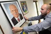Portrét dosluhujícího prezidenta Václava Klause ve všech školách či úřadech fotografie nové hlavy státu nenahradí. Na zdi tříd či pracoven leckde vyvěsí státní znak.