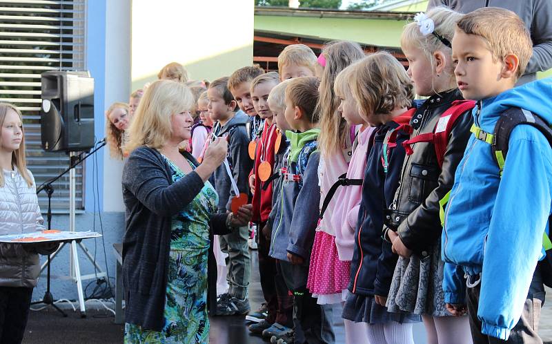 Pasování prvňáčků a předávání diplomů na školním dvoře.