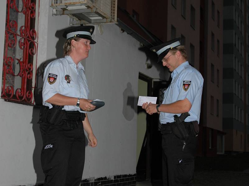 Strážnice a strážník Městské policie v Českých Budějovicích se připravují před jedním z barů na kontrolu nalévání alkoholu mladistvým.  Snímek je z noční akce ze středy.
