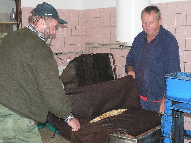 V moštárně zahrádkářů v Nových Hodějovicích už je sezóna v plném proudu. Vojtěch Bíca a Jindřich Houbauer (vpravo) připravují jablečnou drť do lisu.