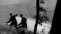 Vzhůru na vor. Herci slézají ve filmu po břehu  k vodě a nastupují na dřevěné plavidlo. 