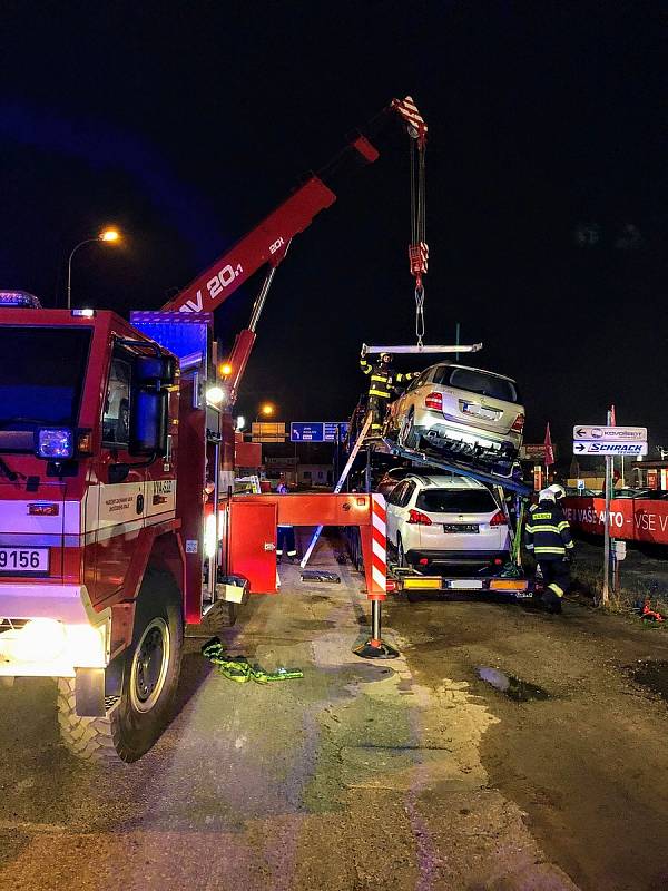 Tahač převážející osobní auta měl poškozený nosník. Hasiči v Českých Budějovicích ve středu v časných ranních hodinách museli náklad zajistit a nebezpečně nakloněné auto sundat.