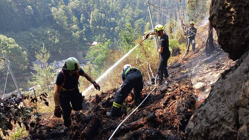 Jihočeští hasiči za pomoci lezecké techniky zasahují v extrémním prostředí skal nad Hřenskem.
