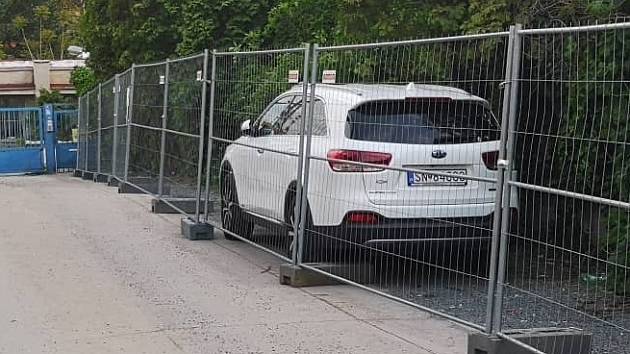 V brněnské Francouzské ulici dělníci obehnali dočasným plotem zaparkované auto.