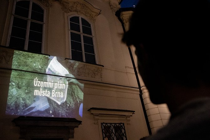 Promítání videa k připomínkování návrhu nového územního plánu na budovu brněnského magistrátu, za kterým stojí organizace Nesehnutí.