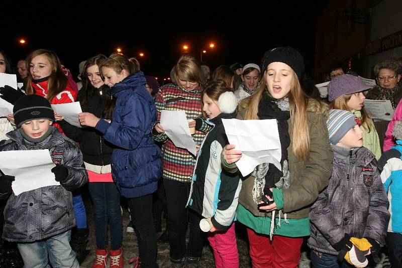 Krátce po šesté hodině večer zpívá koledy na náměstí v Pohořelicích na Brněnsku asi sto padesát lidí pod vedením pohořelického sboru Mužáků.