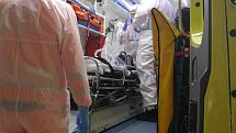 Zdravotníci ze svatoanenské nemocnice nakládají covidové pacienty do speciální sanitky. Ta je odváží do pražských nemocnic.