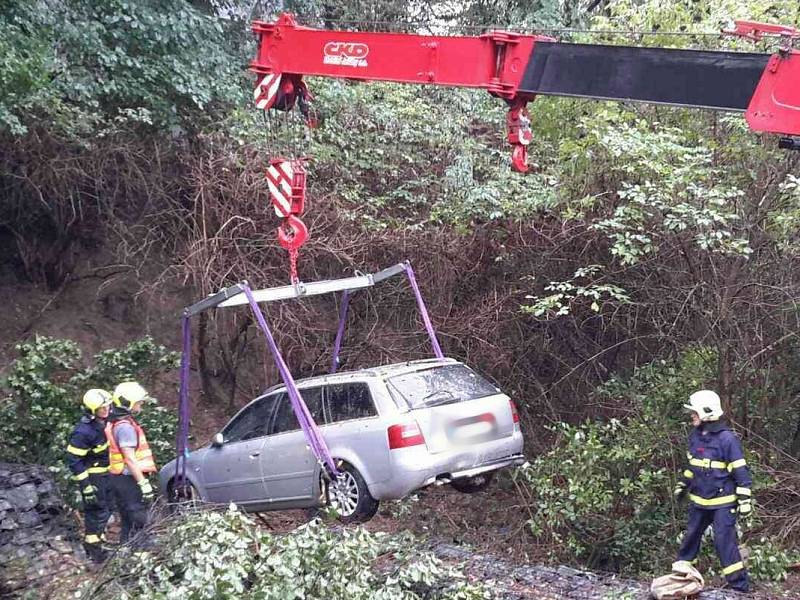 Osobní auto, které zůstalo stát šest metrů pod srázem porostlým dřevinami, vyprošťovali v úterý po sedmé hodině ranní v Židlochovicích hasiči.