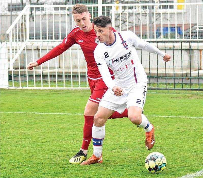 Líšeňský forvard Jan Silný (v bílém) drží míč před jedním z chrudimských fotbalistů.