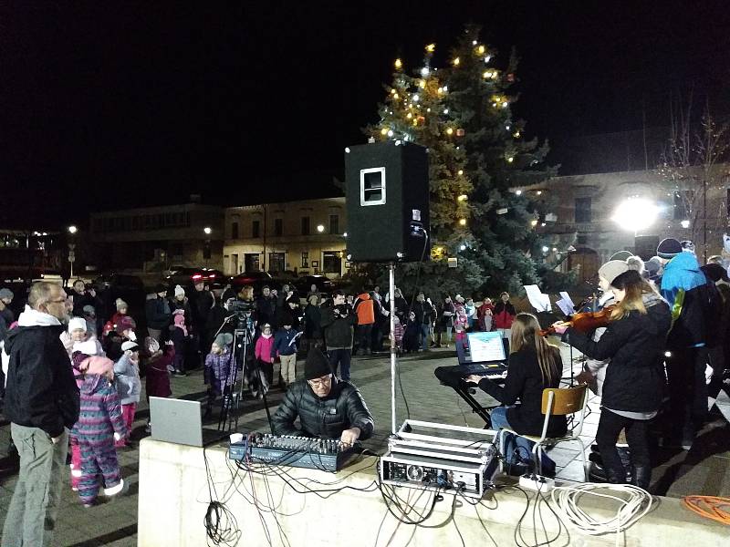 Vánoční atmosféru si připomněli lidé na náměstí v Kloboukách u Brna. Sešlo se tam asi dvě stě padesát zpěváků. Pět desítek studentů gymnázia ke zpěvu i zahrálo. Foto: Renata Pilařová