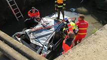 Auto převrácené na střechu potopené střechou do bahna. Řidič v něm zůstal připoutaný k sedadlu. A zraněný.