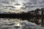 Zrcadlo mraků a Slunce na hladině jezera Opleta, největšího v území přírodní památky Holásecká jezera.