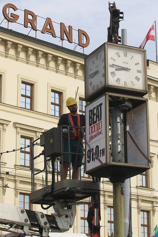 Odstranění starých a nefunkční otočných hodin v brněnské Benešově ulici. Nahradí je nové.