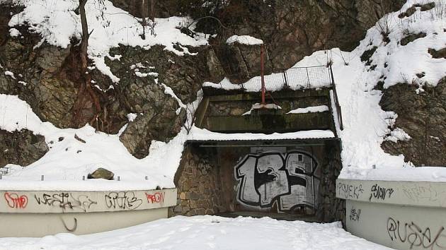 TAJEMNÁ ŠTOLA. Kovová vrata skrývala sklad chloru, nyní je za nimi soukromá dílna. Stáří štoly je však nejasné.