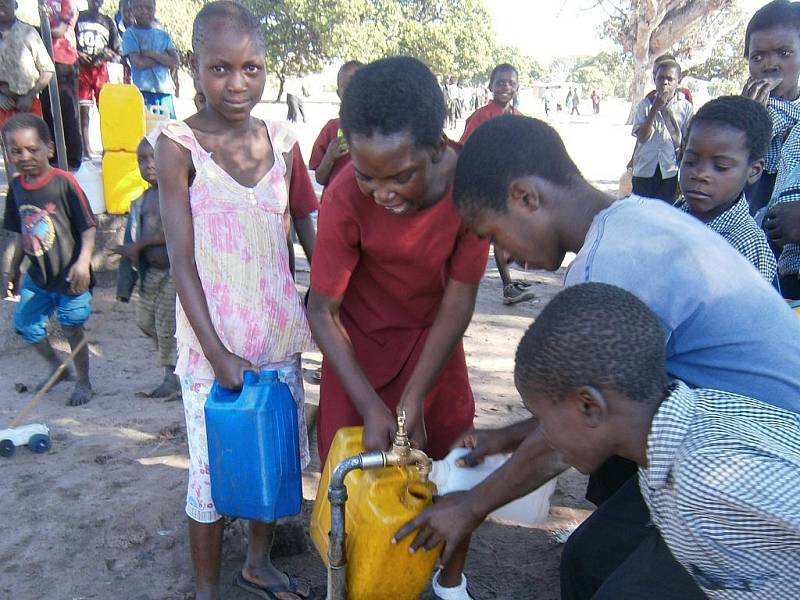 Komunitní kohoutek s vodou u stavby školy využívají i lidé z okolí.