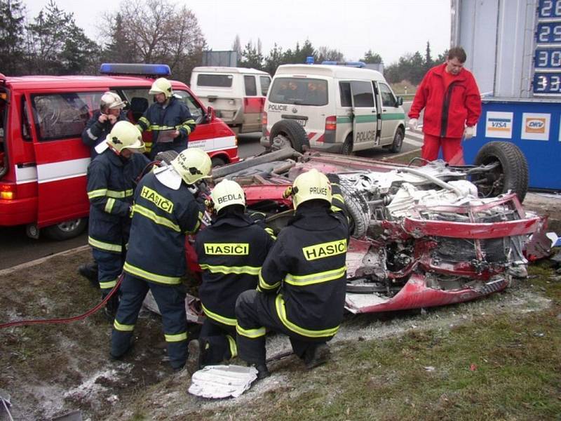 Hasiči likvidují vrak havarovaného auta