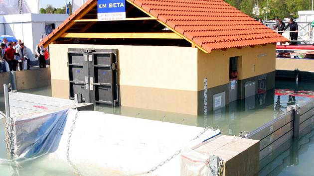 Povodně ve zmenšeném měřítku se odehrávají v bazénu, v němž je postavený model rodinného domu.