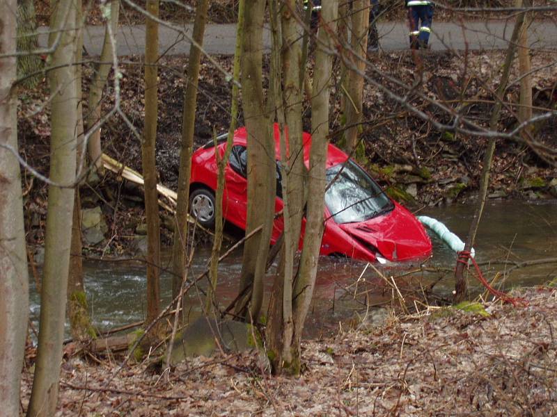 Hasiči vytahují osobní vůz Peugeot z vody.