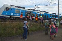 U Vojkovic lidem ze stojícího vlaku pomáhali hasiči Správy železniční dopravní cesty.