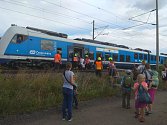 U Vojkovic lidem ze stojícího vlaku pomáhali hasiči Správy železniční dopravní cesty.