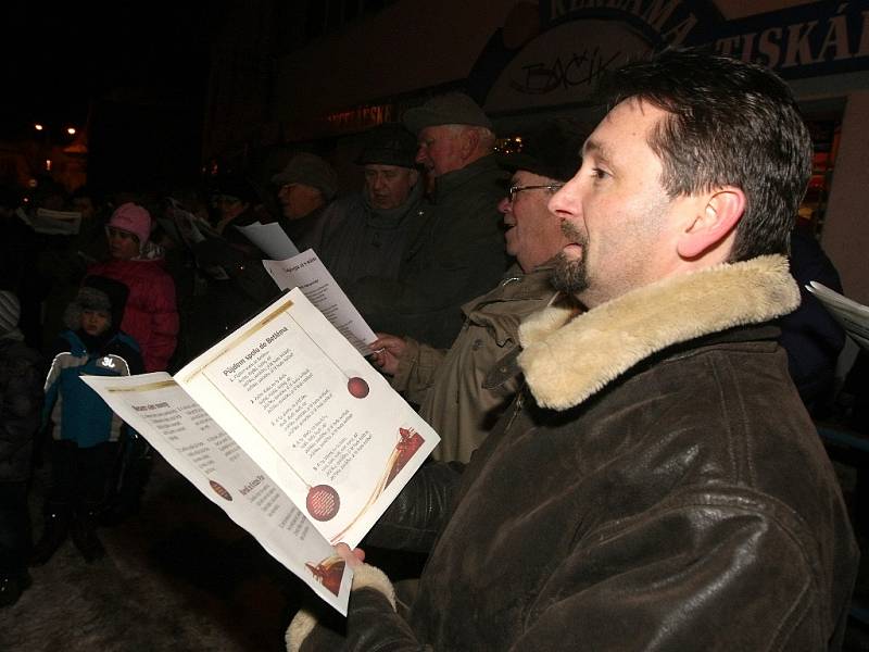 Krátce po šesté hodině večer zpívá koledy na náměstí v Pohořelicích na Brněnsku asi sto padesát lidí pod vedením pohořelického sboru Mužáků.