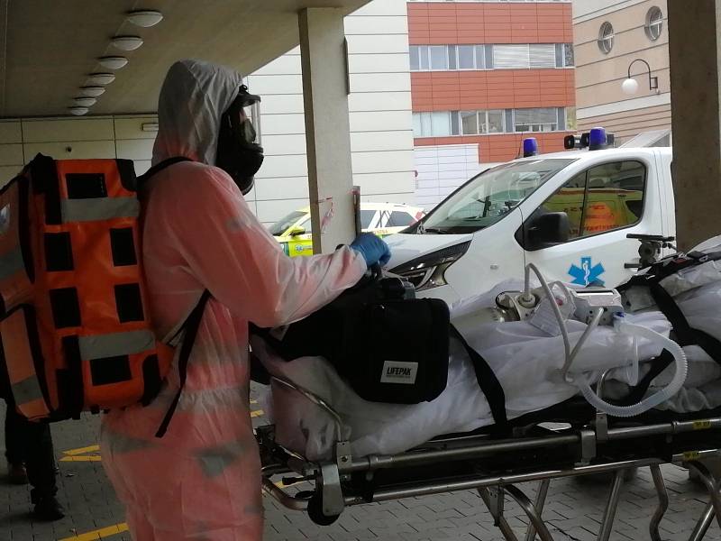 Zdravotníci ze svatoanenské nemocnice nakládají covidové pacienty do speciální sanitky. Ta je odveze do pražských nemocnic.