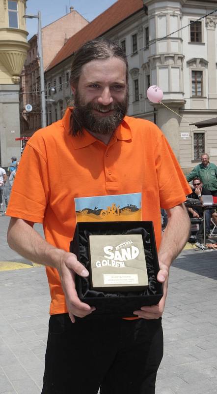 Mohutný pískový kvádr s vymodelovaným vnitřním schodištěm určila odborná porota za vítěze soutěže Golden sand festival. Autorem sochy je Slovák Martin Pokorný (na snímku).