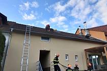 V brněnských Obřanech hasiči v úterý odpoledne zachránili ze střechy rodinného domu rotvajlera.