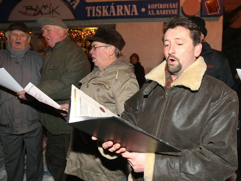 Krátce po šesté hodině večer zpívá koledy na náměstí v Pohořelicích na Brněnsku asi sto padesát lidí pod vedením pohořelického sboru Mužáků.