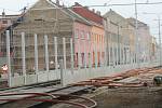 Dělníci staví kolem nové tramvajové tratě na Plotní vysoké a betonové protihlukové stěny.